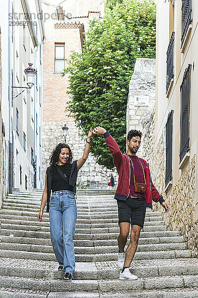 Man holding girlfriend's hand and moving down steps