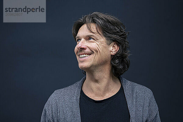 Happy mature man against blue background