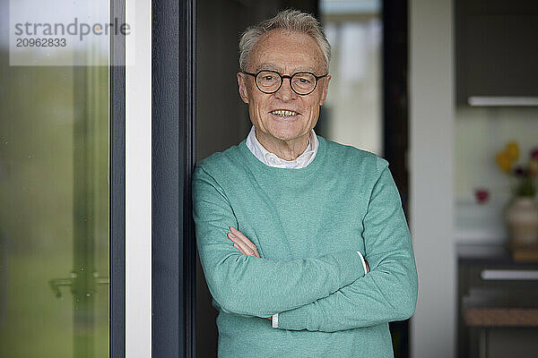 Portrait of smiling senior man at home