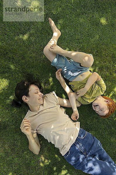 Mother and son lying down on grass