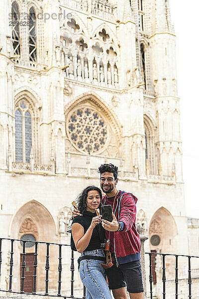 Couple taking selfie standing in front of Burgos Cathedral