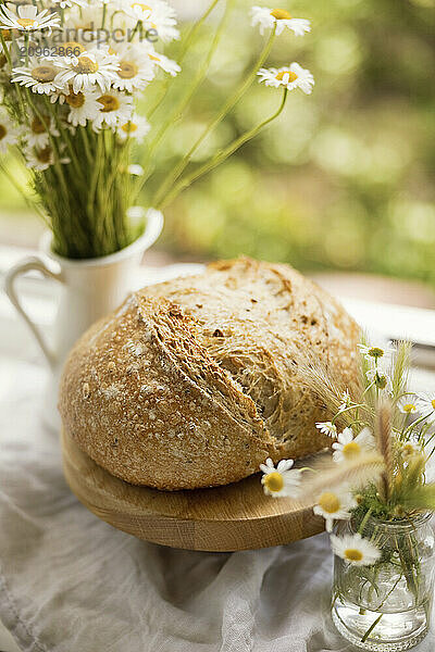 Daisies in vase and freshly baked homemade sourdough bread