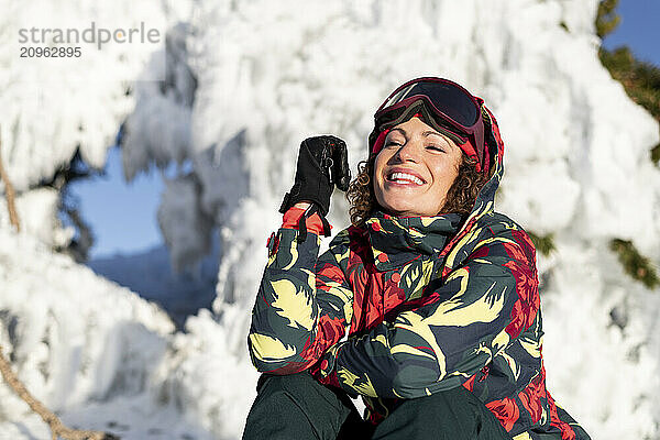 Happy woman sitting in ski-wear