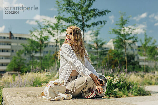 Long haired woman sitting cross-legged at park