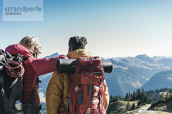 Friends with backpacks looking at view on Tannheim Valley