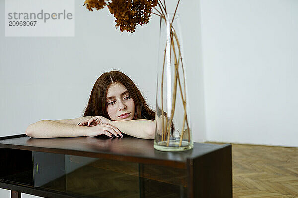 Woman leaning on table at home