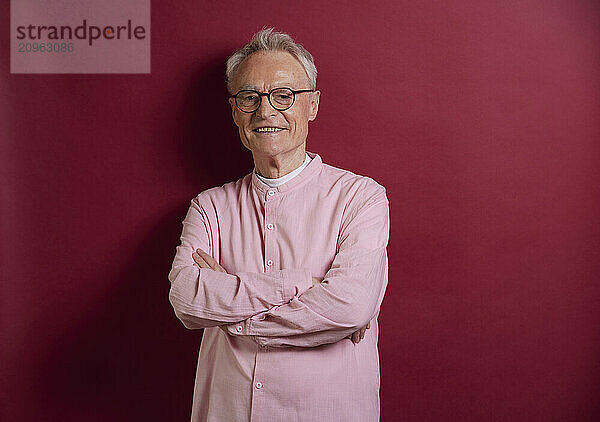 Portrait of confident senior man against purple background