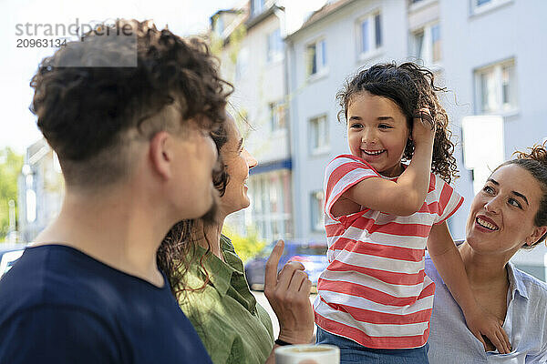 Cute girl enjoying leisure time with family and friends at street