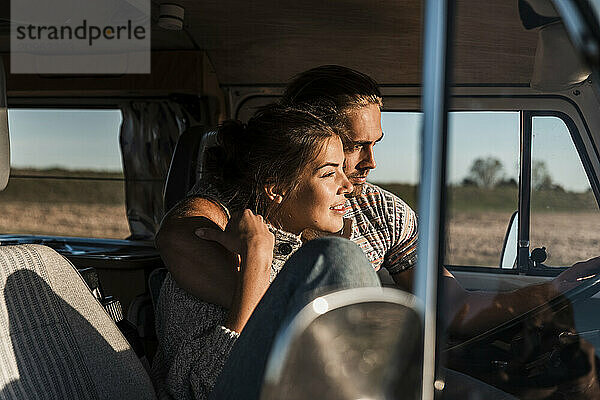 Affectionate young couple traveling in camper van