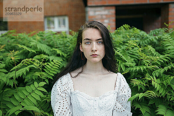 Girl standing between plants in garden