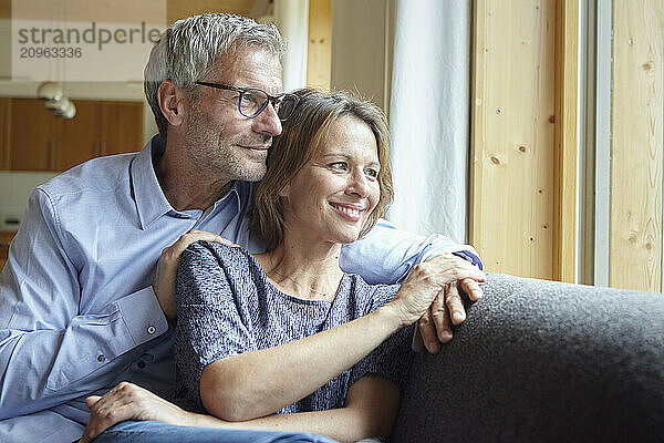 Couple spending leisure time sitting on sofa at home