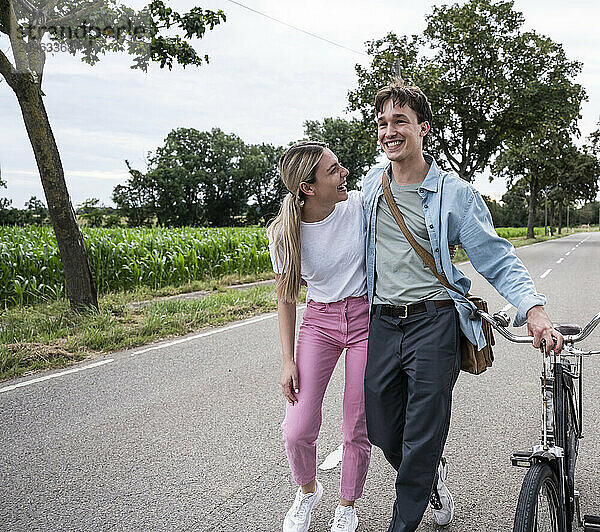 Carefree young woman walking with boyfriend on road