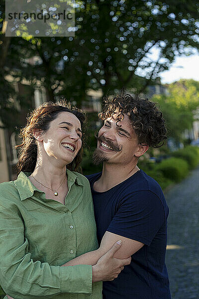 Cheerful man with girlfriend standing at street