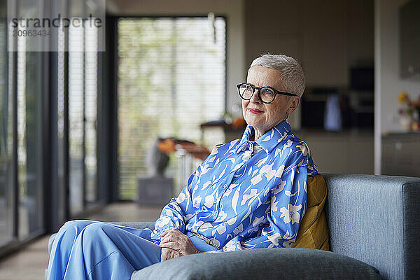 Senior woman sitting on couch at home