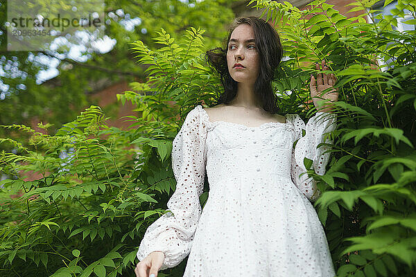 Girl standing between plants in garden