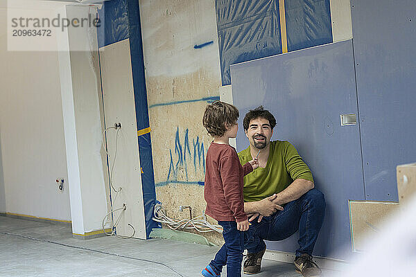 Father and son spending leisure time in new apartment