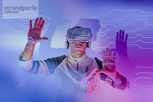 Man wearing virtual reality simulators gesturing and touching transparent screen