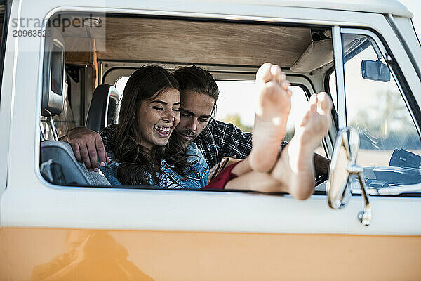 Young couple using tablet PC in camper van