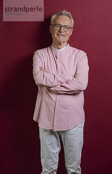 Portrait of confident senior man against purple background