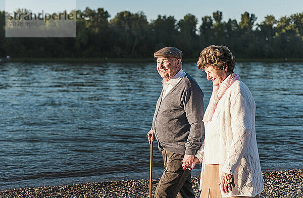 Happy senior couple walking at riverbank