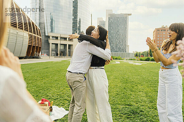 Cheerful couple hugging each other in front of buildings