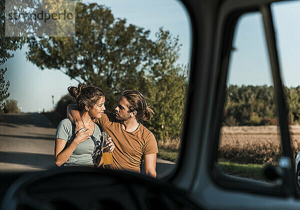 Young couple with arm around walking on road