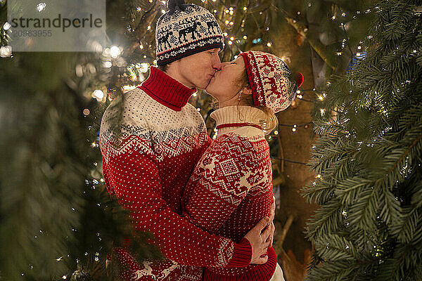 Couple kissing under christmas tree