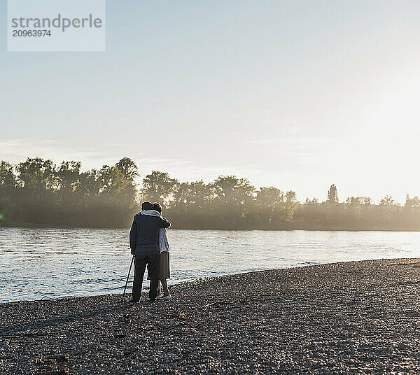 Senior couple hugging together near river