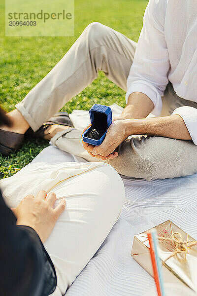 Man gifting ring to woman in park