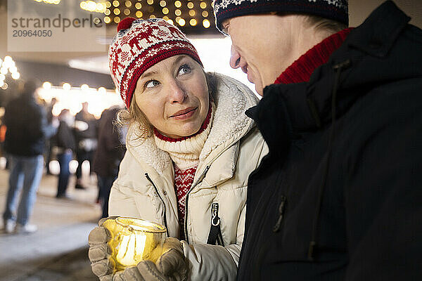 Beautiful woman and man looking at each other in christmas market