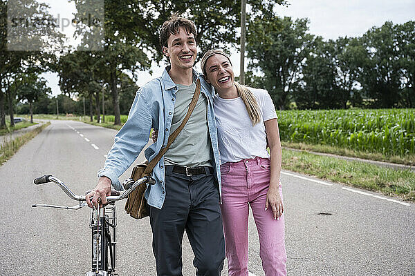 Happy young woman walking with boyfriend on road