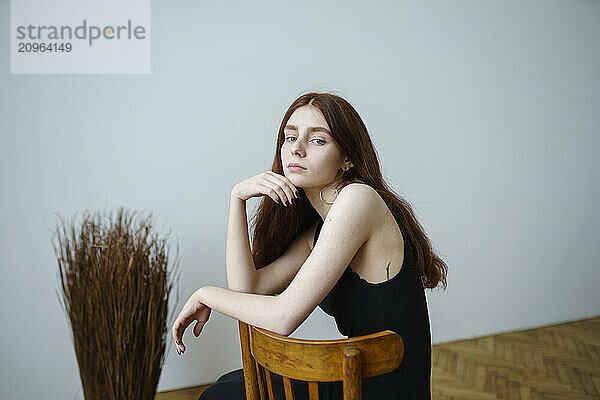 Young woman sitting on chair at home