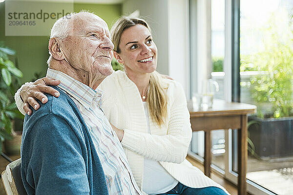 Thoughtful senior man with daughter sitting at home