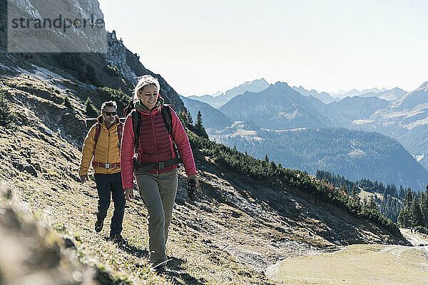 Mature woman hiking with friend on mountain