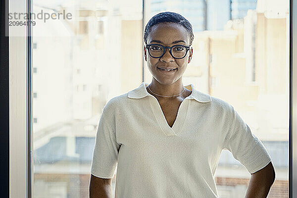 Confident businesswoman with eyeglasses at office