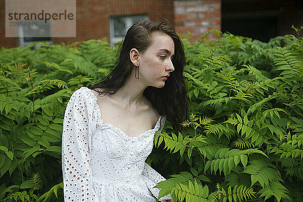 Girl looking at plant in garden