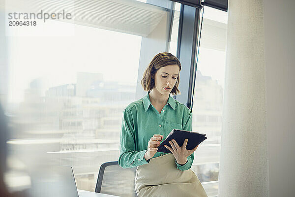 Businesswoman using tablet PC at workplace