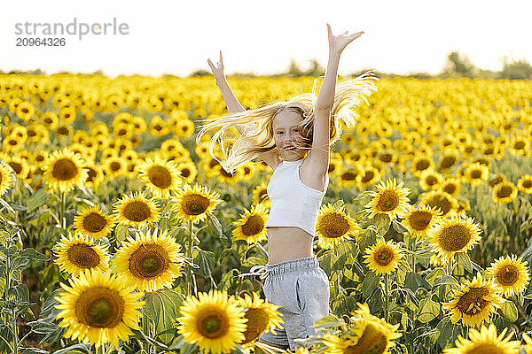 Girl jumping in sunflower field