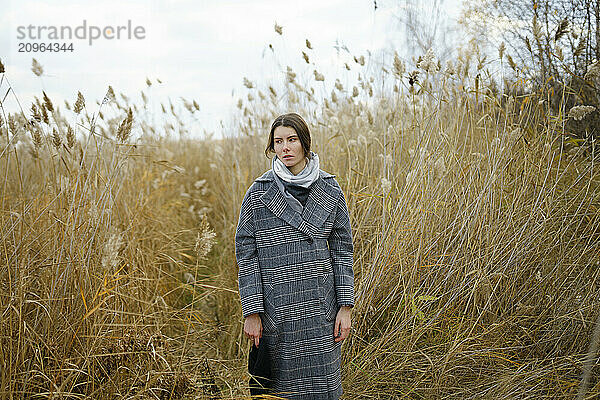 Beautiful woman standing in field surrounded by pampas