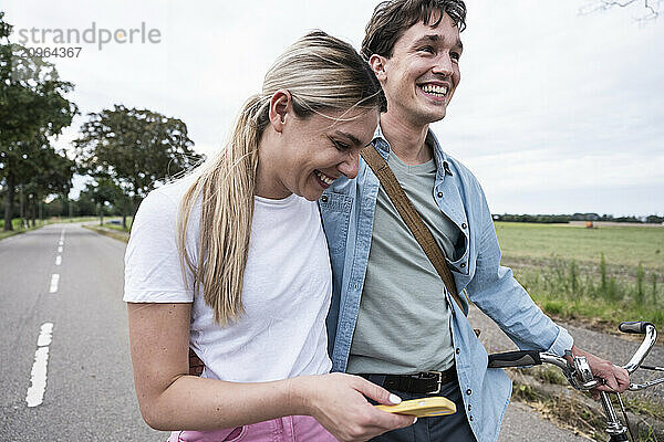 Cheerful young couple walking on road