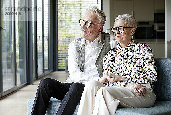 Senior couple sitting on couch at home