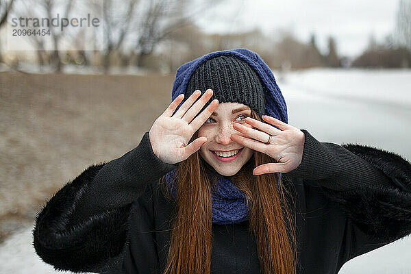 Redhead woman smiling and gesturing in winter