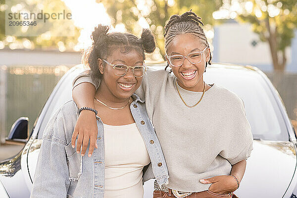 Young women laughing together looking at camera