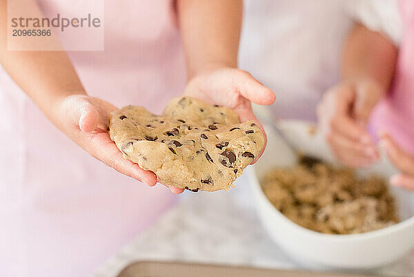 Close up of Girl holding cookie dough in her hands