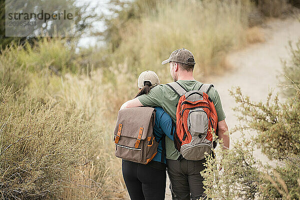 Couple walking on a trail with their arms around each other