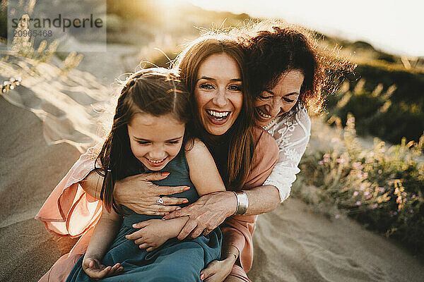 Three generations laughing women mom grandma girl beach sunset Spain