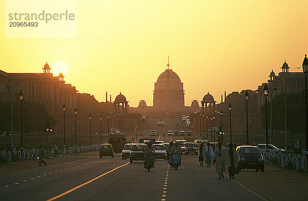 Men on bicycle in front of the Capital building in New Delhi  India  at sunset.