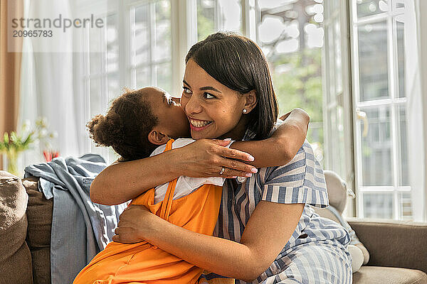 African American woman and daughter hugging closely