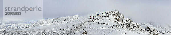 Climbers on a busy summit day going and returning from Uhuru Peak  the highest point of Mt. Kilimanjaro  Tanzania.