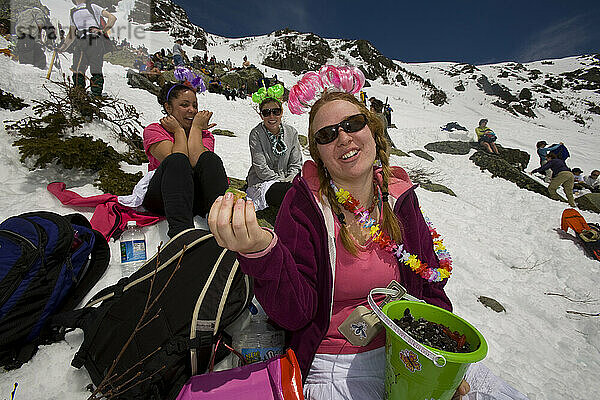 Skiers eat snacks while resting on Tuckerman Ravine on Mount Washington in the White Mountains of New Hampshire.